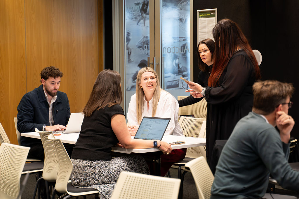 A group of participants talking through ideas together around a table